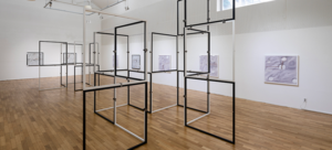 A installation view of modular sculpture comprised of 44 inch my 44 inch black and white aluminum frames stacked both horizontally and vertically.