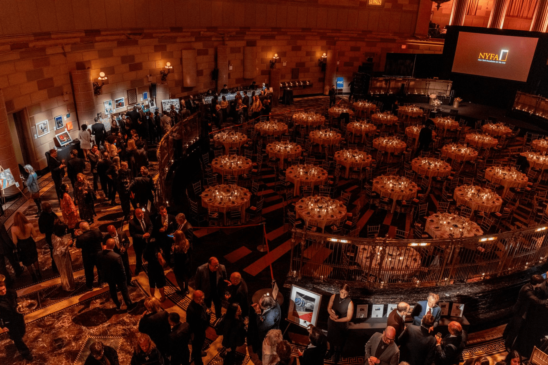 Aerial view of NYFA's 2024 Hall of Fame Benefit, looking down on the cocktail hour and art auction and circular tables set for dinner.