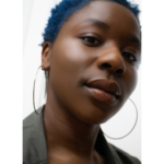 Aliyah Curry headshot; a Black woman with short blue hair looks into the camera from an above angle.