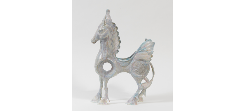 Sculpture of a fantastical iridescent horse with wings and a hole in the center.