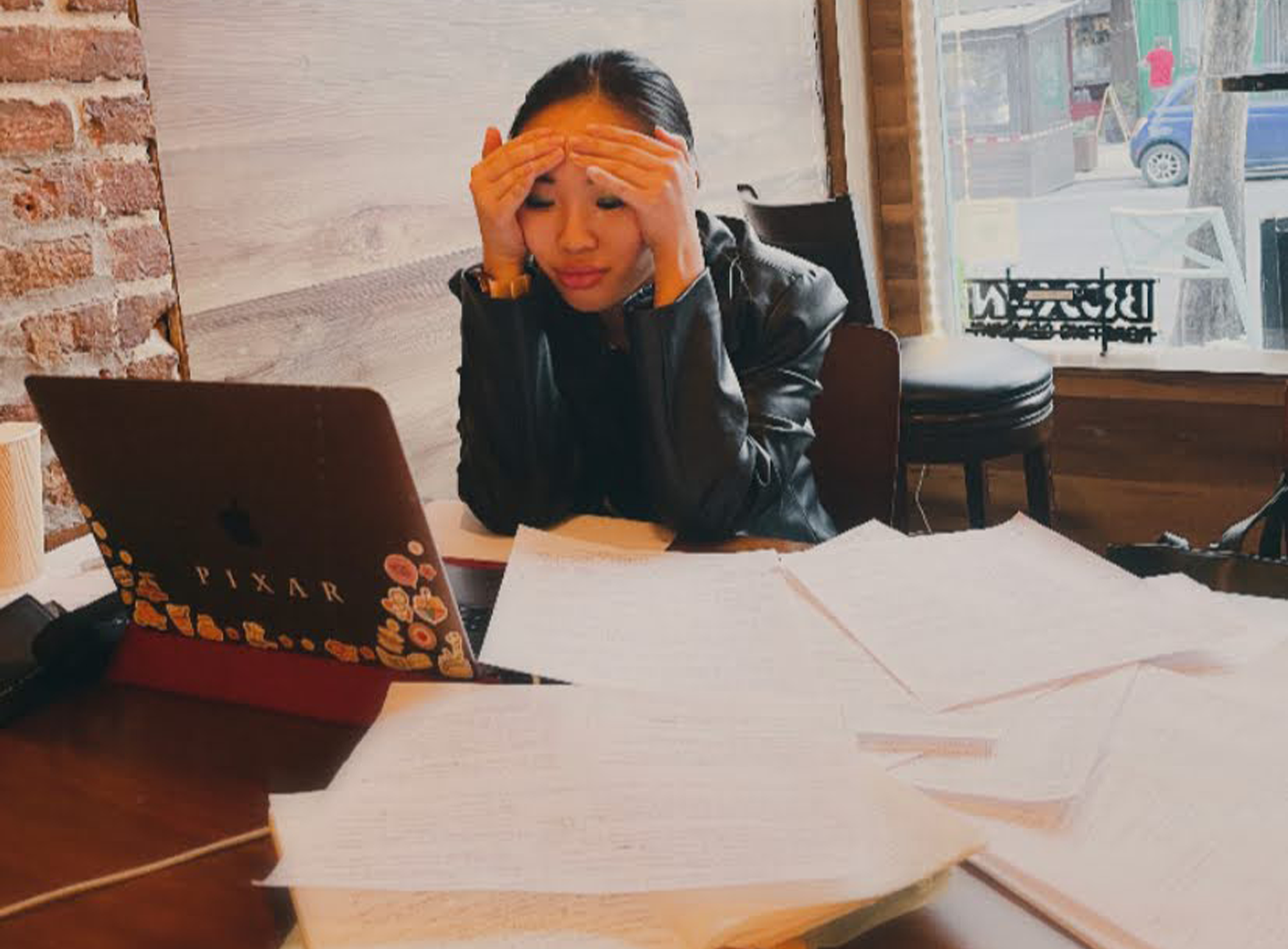 Jemimah Wei during the revision process, at her computer with papers strewn on the desk before her