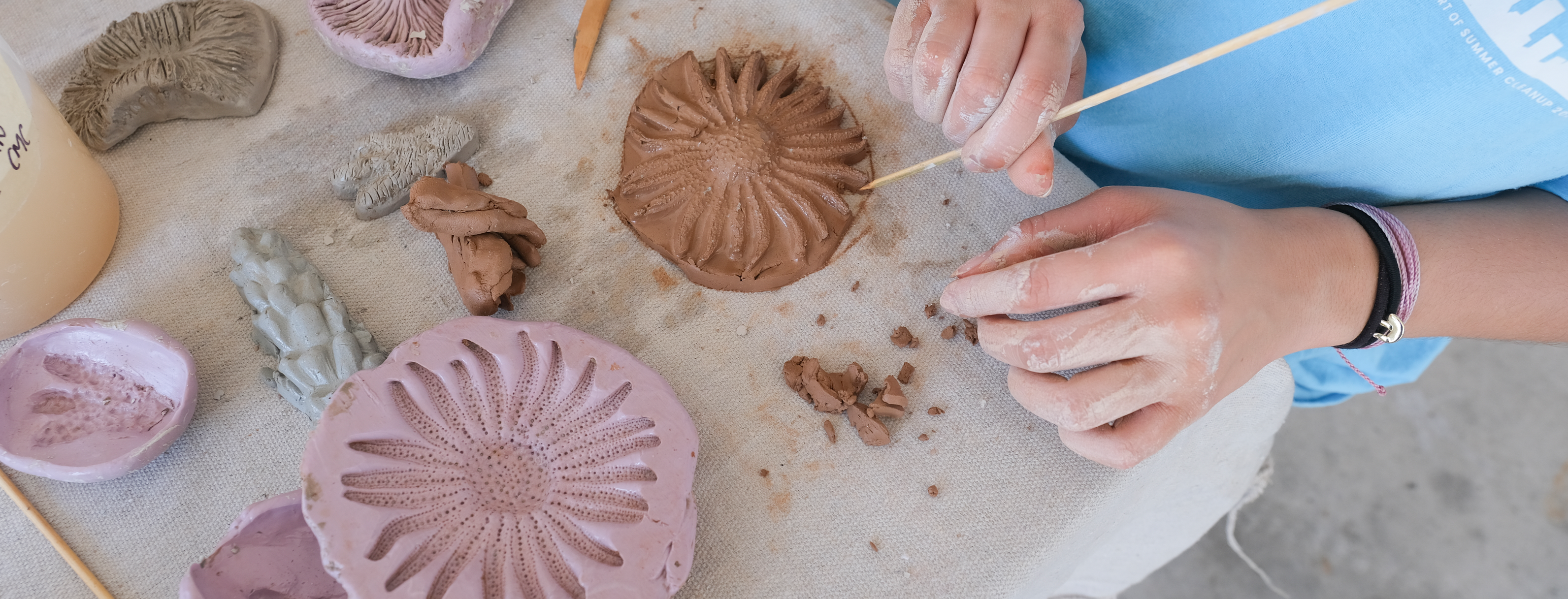 A volunteer presses clay into molds of various corals that Lauren Shapiro created for "The Blue Horizon Project"