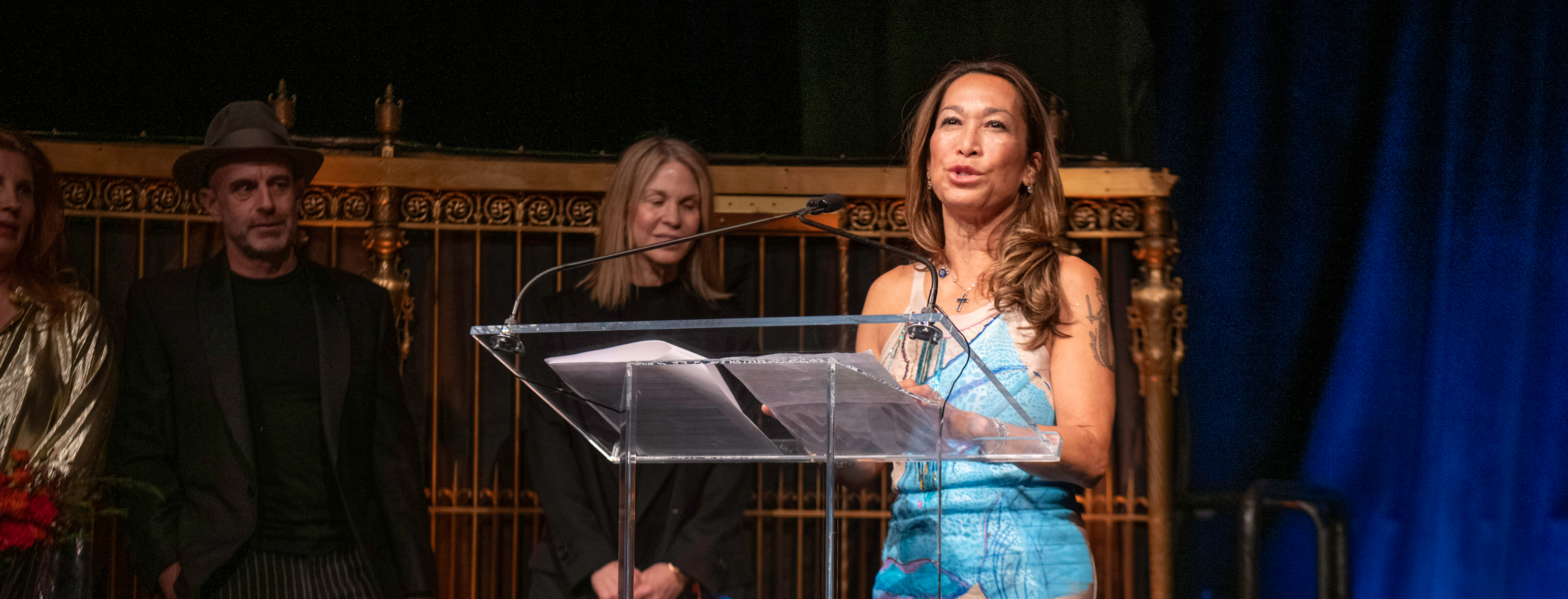 Cristina Enriquez-Bocobo addressing the crowd behind a podium at NYFA's 2025 Hall of Fame Benefit