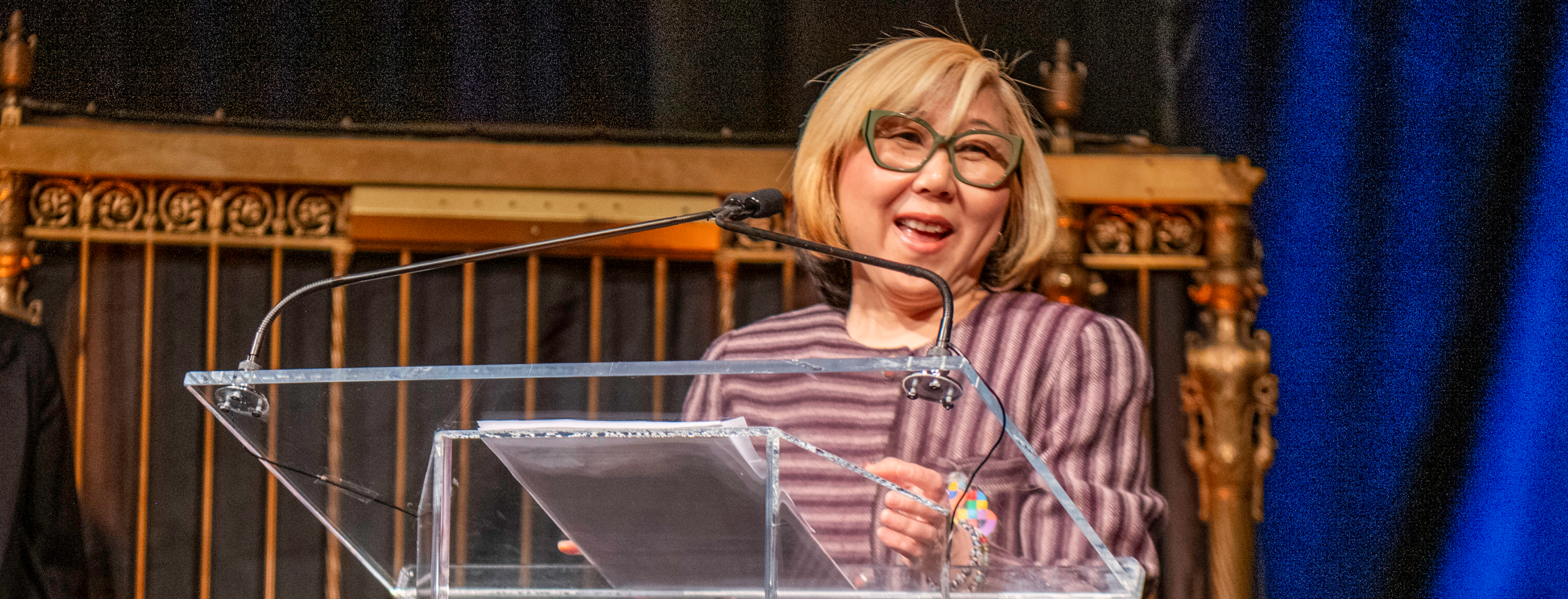 Jaye Moon giving her acceptance speech behind a podium