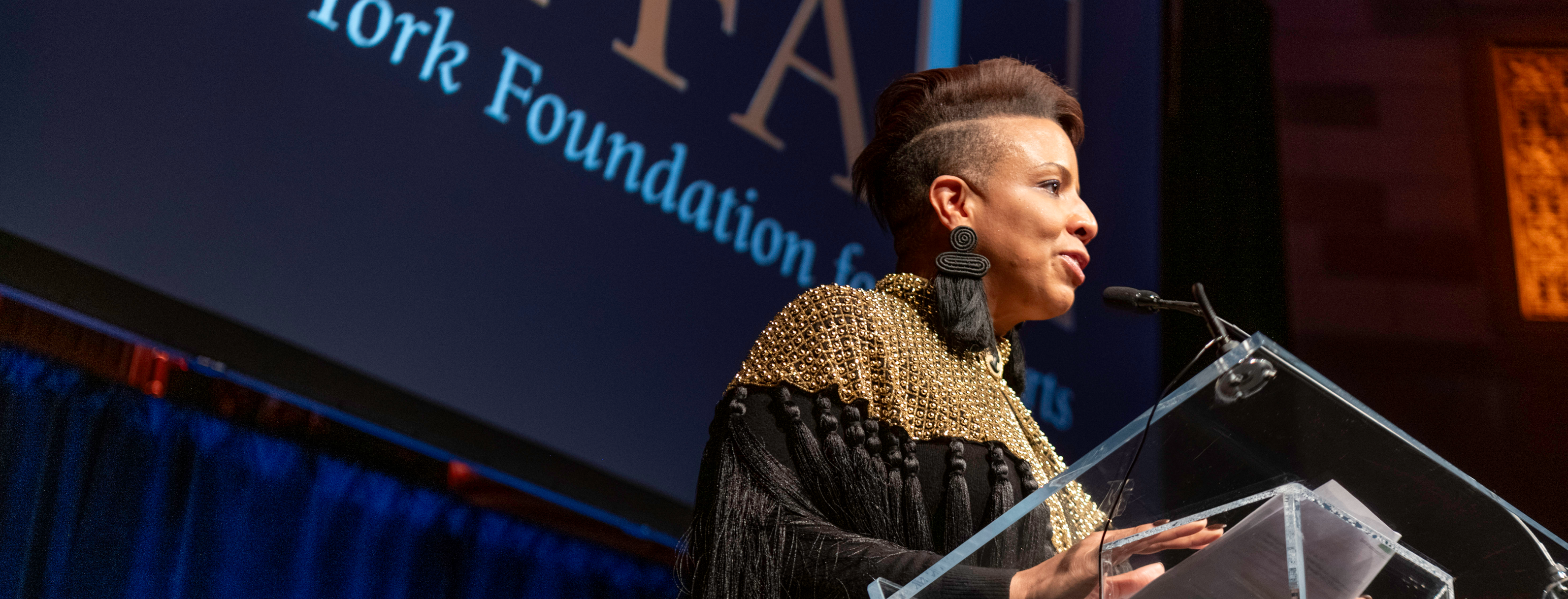 Commissioner Laurie Cumbo behind a podium at NYFA's Hall of Fame Benefit